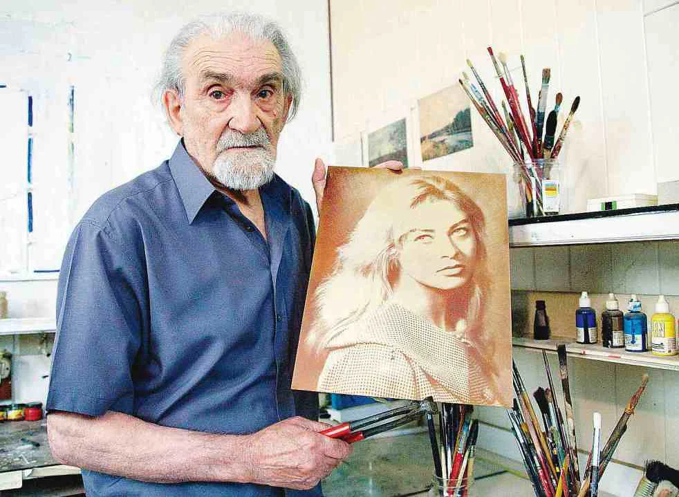 immagine del maestro nicorelli che tiene in mano una lastra della scomposizione della luce appena realizzata